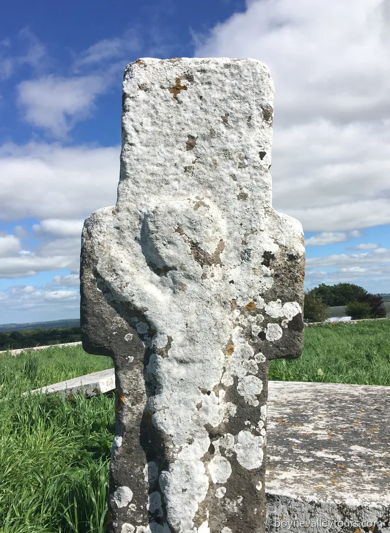 Late medieval stone cross with a weathered Crucifixion carving in the Hill of Skryne churchyard.