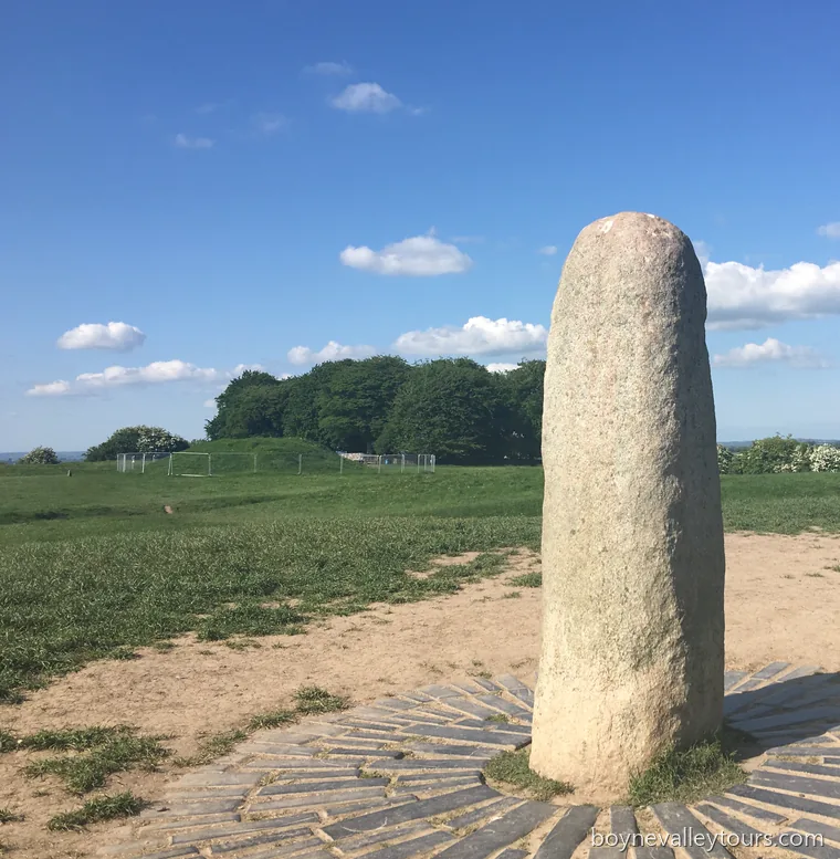The Lia Fáil, the Stone of Destiny, standing on the Hill of Tara under a blue sky.